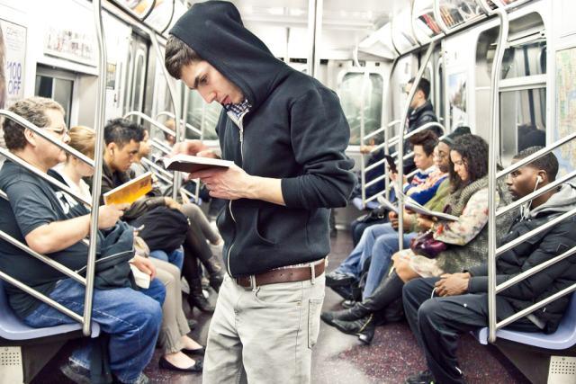 国外乘客在地铁上看书看报纸
